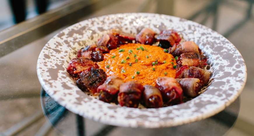 Bacon-Wrapped, Andouille-Stuffed Dates with Pecan Romesco Sauce